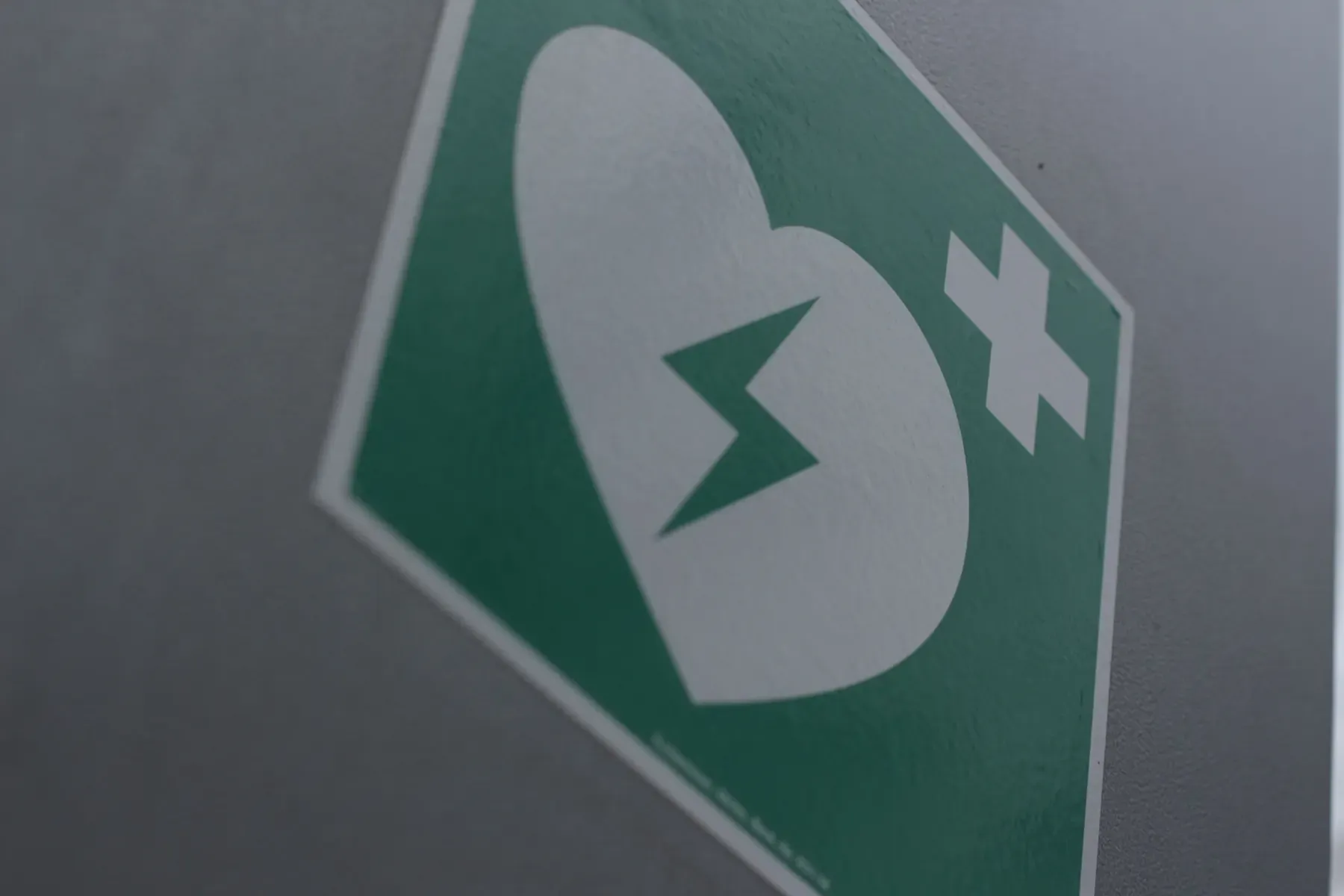 A site safety sign marking a defibrillator and first-aid point
